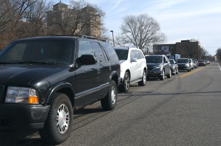 A line of cars stretches from Kendall Street back to Washington Avenue as people picked up boxes of food, personal protection and children supplies on Saturday morning.