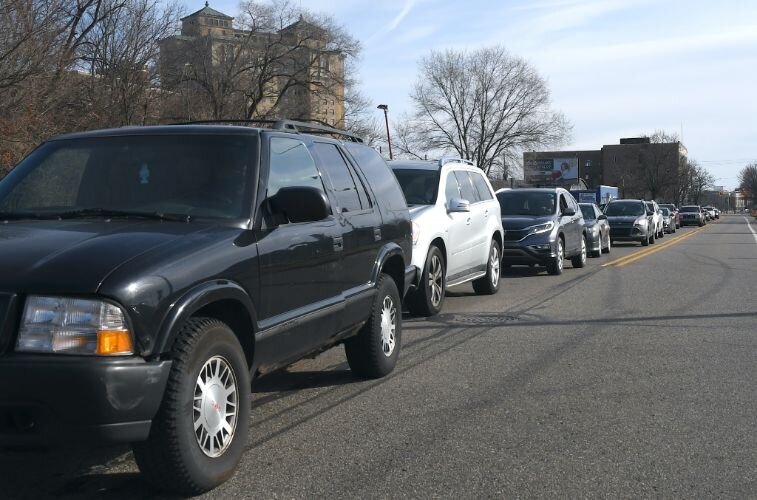 A line of cars stretched from Kendall Street back to Washington Avenue as people picked up boxes of food, personal protection, and supplies for  children.