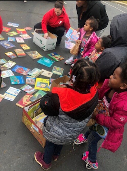 YMCA@Lincoln Program Director Jennifer Shea is shown distributing free books to kids in the neighborhood.