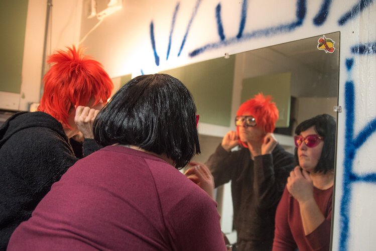 Dormouse Theatre Troupe members Stephen Dupuie and Adrienne Waller get into character as they don wigs and props in the dressing room of their new soon-to-open performing arts theater in Kalamazoo’s Edison Neighborhood.