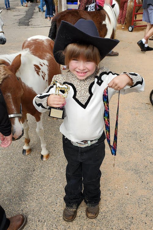 Hadlee Strunk stands with her miniature horse, Tweety, after finishing class during last year’s Calhoun County Fair.  She received a ribbon and trophy for her efforts.