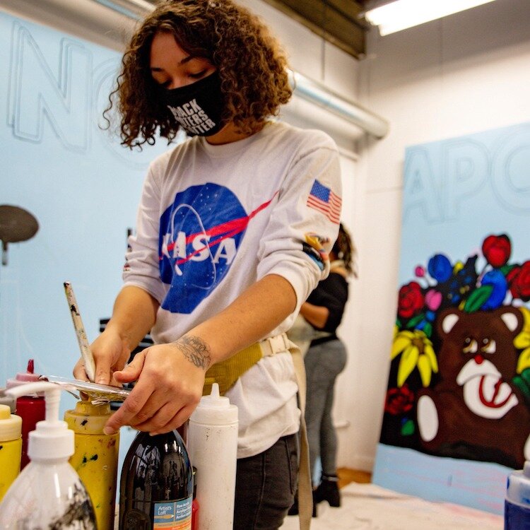 Maya James working on “No Weapons Formed”, a community collaboration mural organized by Nicole Lee of Imagine Art N Lee in Kalamazoo, Michigan 