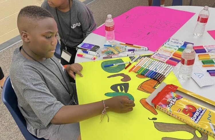 A young man is shown creating an anti-violence poster during last year’s Life Camp in Kalamazoo