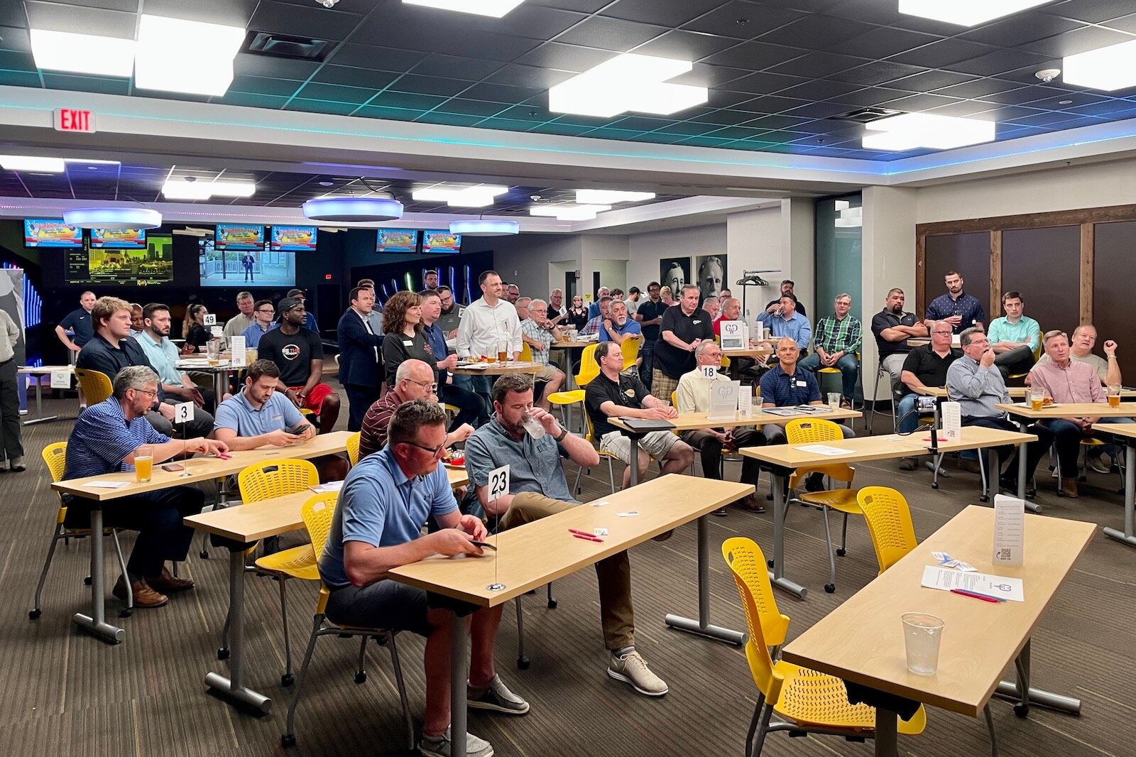 Members of Guys Who Give consider information about nonprofit organizations at a recent meeting held at the Revel & Roll West entertainment center in Kalamazoo.