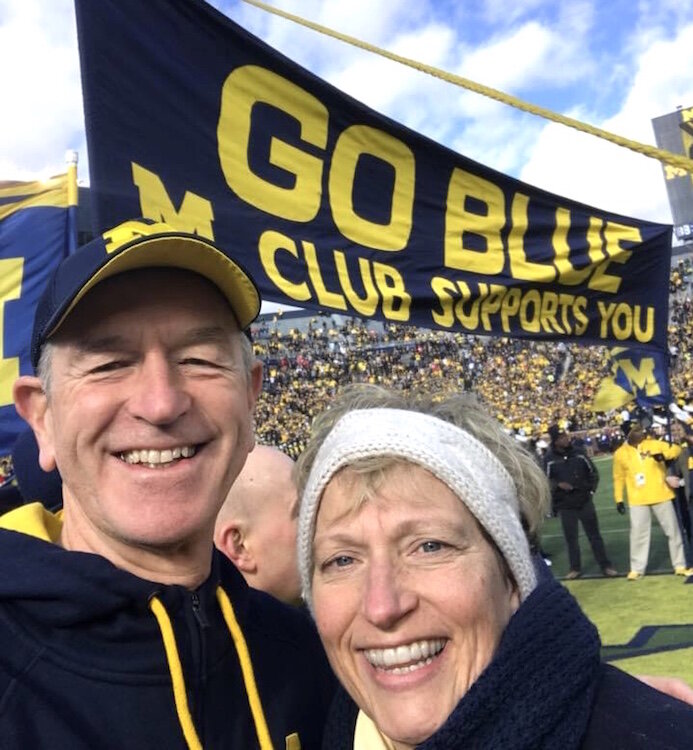 Jim and Jeanne Hess hold the "Go Blue" banner at the Nov. 25, 2017 University of Michigan home football game against Ohio State University. The thrill of football at Michigan Stadium, dubbed "The Big House," seems a long way off.