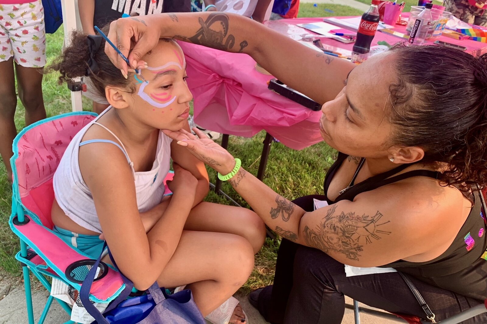 Ashlee Hooker, right, paints the face of a youngster during National Night Out in the Northside Neighborhood.