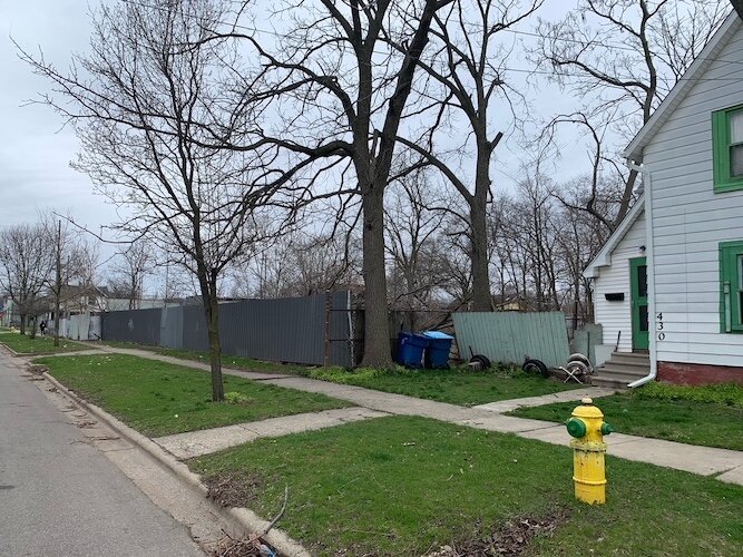 A brown wooden fence separates some of the vacant land in the 400 block of West Ransom Street from view. It is to become the location of four new single-family homes.