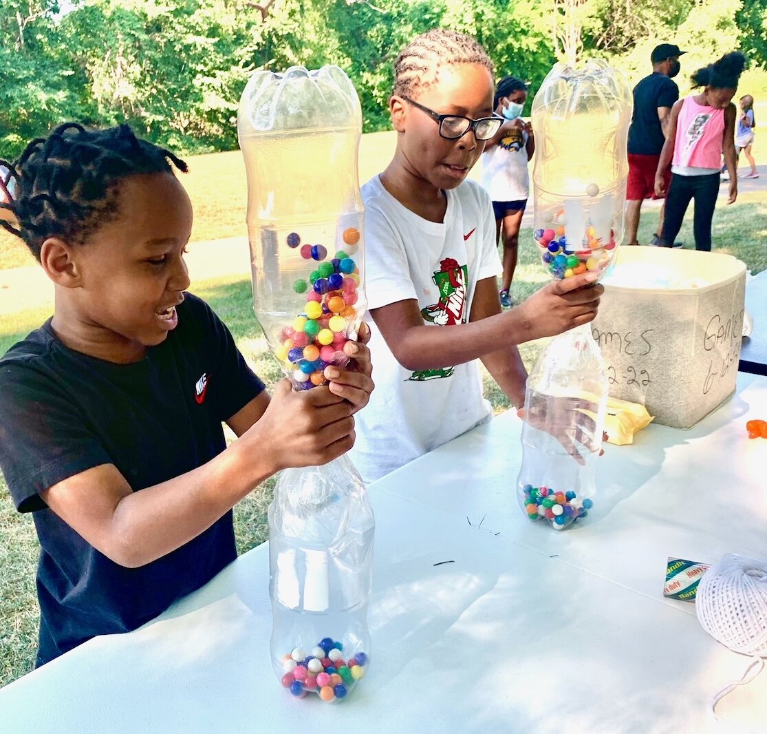 Two youngsters play a gumball race game during National Night Out in Kalamazoo’s Eastside Neighborhood. It was at Rockwell Park on Trimble Avenue. Photo by Al Jones