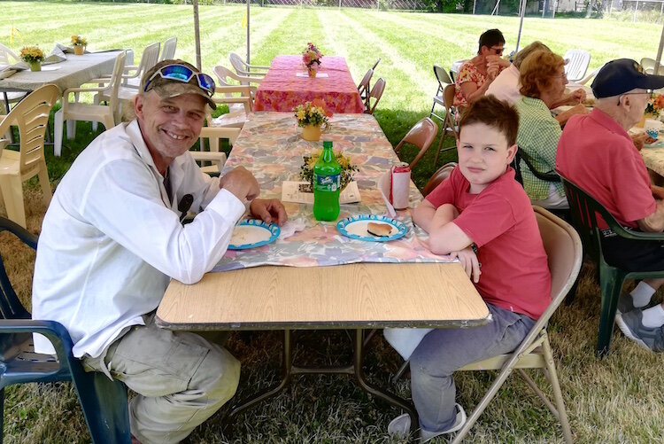 Ron Kneen and his son Henry enjoy food and camaraderie at the 2019 Oakwood Neighborhood Reunion. The reunion is always held on the last Sunday of June.