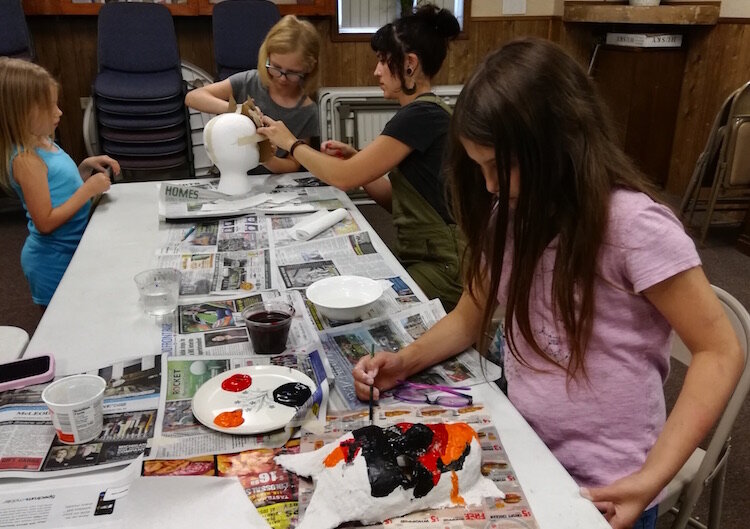 Youngsters work on at projects in the community room of the Oakwood Neighborhood Association Community & Youth Center. They are participating in Oakwood’s Youth Summer Arts Program.