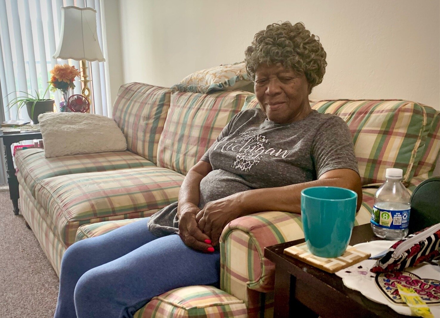 Katherine White relaxes on the sofa of her one-bedroom apartment in Kalamazoo.  