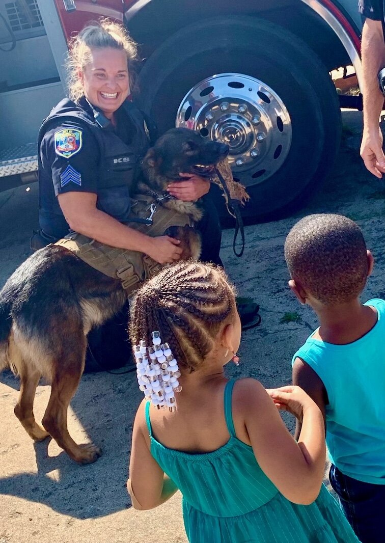 Kalamazoo Public Safety Sgt. Kelly Pittelkow (with Lt. Robert Holdwick) lets children pet  their K-9 partner Norman. Photo by Al Jones