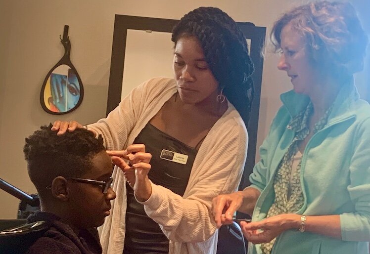 Lalonie Willhite, shown shampooing the hair of 12-year-old Emanuel Frye, learned how to style and cut hair when her foster parents did not know how.