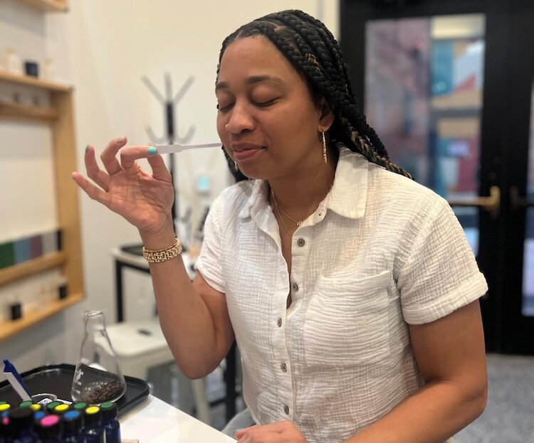 A woman checks some of the 40 unique fragrance oils that can be mixed and matched at The Aroma Labs. They include bright florals, juicy citruses, cozy spices, and deep, woody scents.