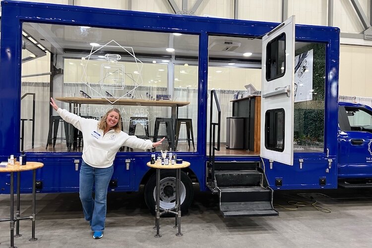 Tanya Thompson stands outside of “Big Blue,” The Aroma Labs’ large Ford F-550 mobile experience.   