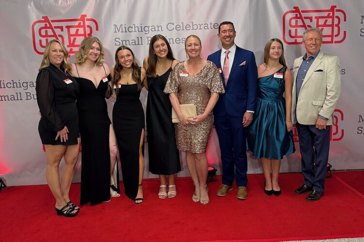Tanya Thompson, center, is joined by family members and friends in April of 2025 in East Lansing after being named one of the top Women-owned Small Businesses of the Year by the Michigan Small Business Administration. See list of names below story.