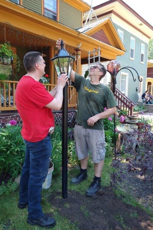 Men finish installing solar lights that residents request in Kalamazoo’s core neighborhoods.