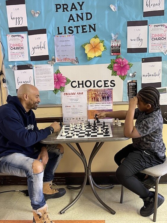 Damon Brown, founder and president of R.I.S.E. plays chess with one of the students in his afterschool program.