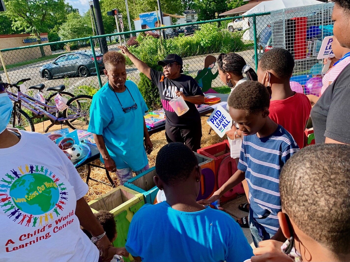 Executive Director Mattie Jordan-Woods, center wearing black, leads a drawing for toys during the Northside Association for Community Development's annual National Night Out on Tuesday, behind the organization's 612 N. Park St. offices.