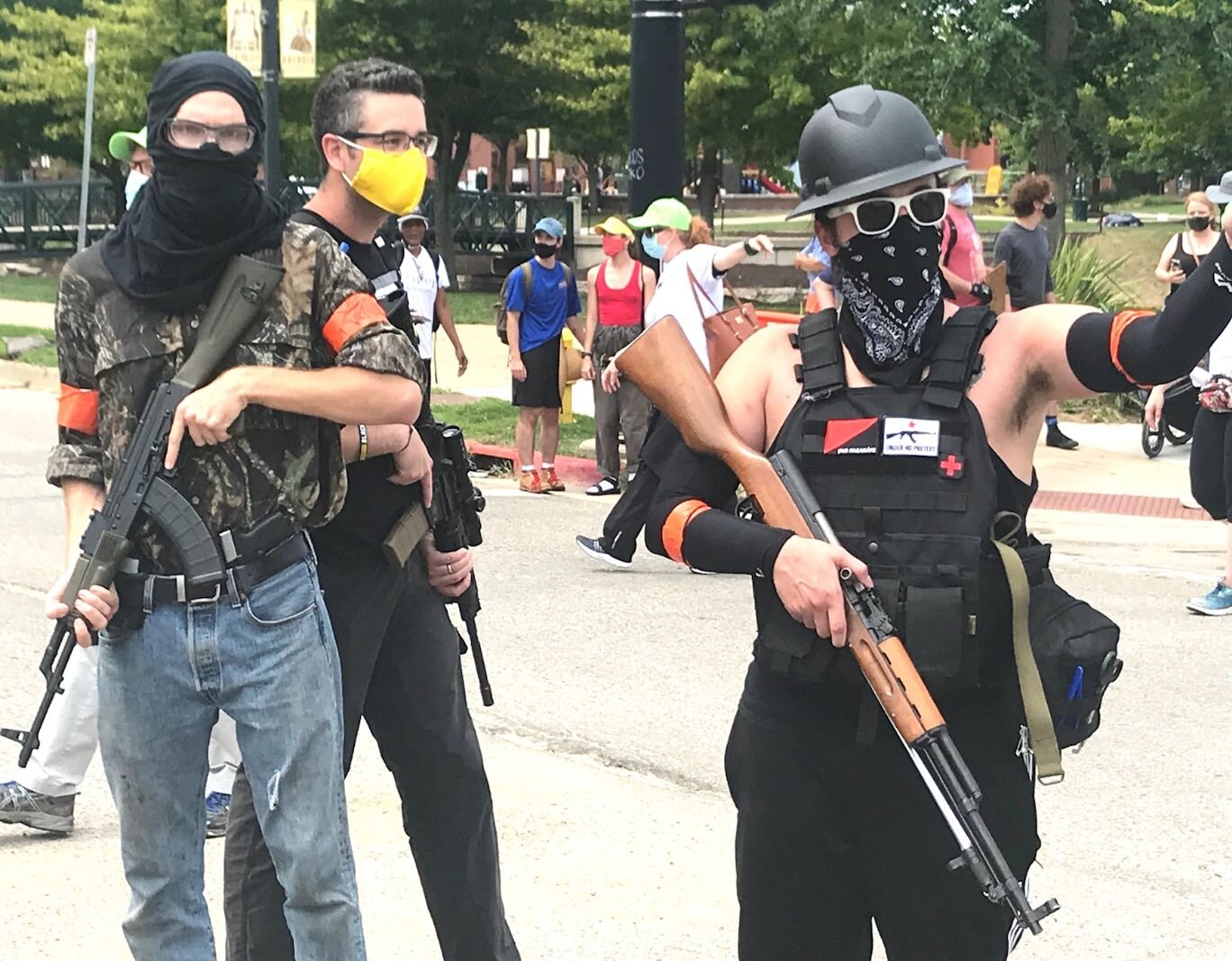 Several members of a Detroit-based citizens defense group carry rifles at a prayer vigil/counter-protest Saturday in downtown Kalamazoo.