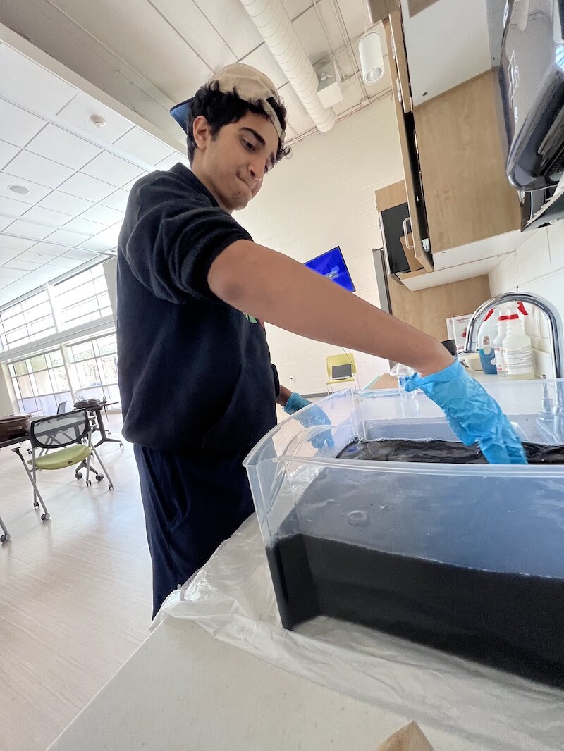 Mahdi Hassnawi dyes a T-Shirt for his Voices of Youth art project .