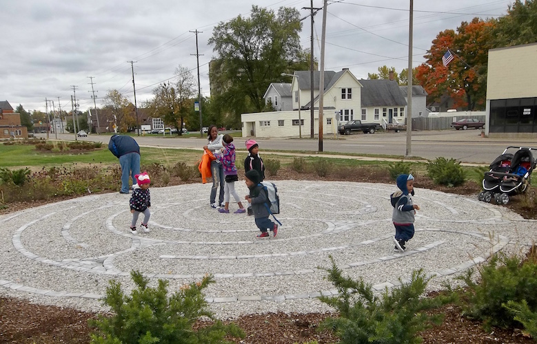 Youngsters are shown in October of 2012 enjoying a game that was included in the "interim landscaping" of native flowers on the site of the former Kalamazoo Creamery Company building after it was demolished at Lake and Portage streets.  