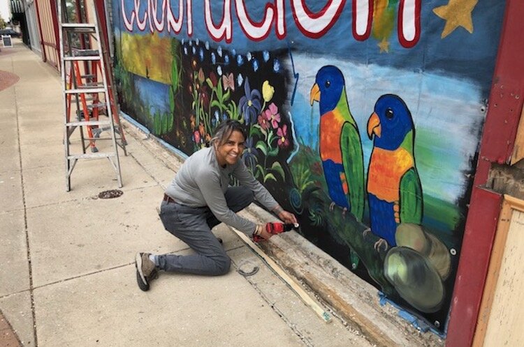 Xenia Rose Schafer, a member of LAGL, works on a mural created by her and fellow LAGL members that is located in front of Torti Taco in downtown Battle Creek.