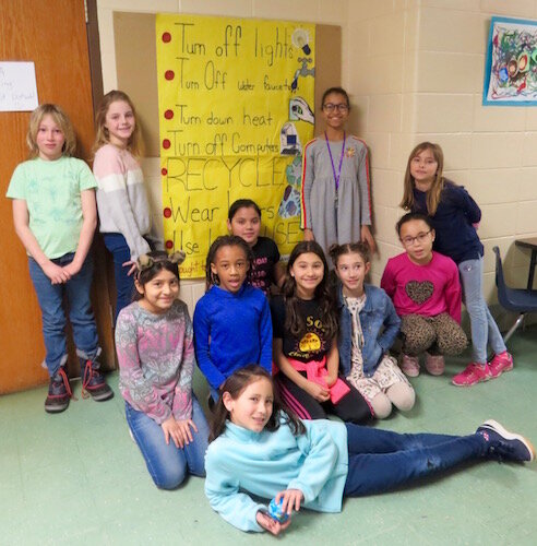 Climate Change Club members pose with their poster of things we can do to make a difference.
