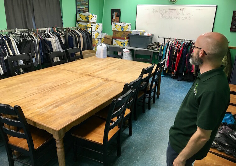 Executive director Robert Elchert stands in the board room of the Share Center. It doubles as a clothing closet for those in need.