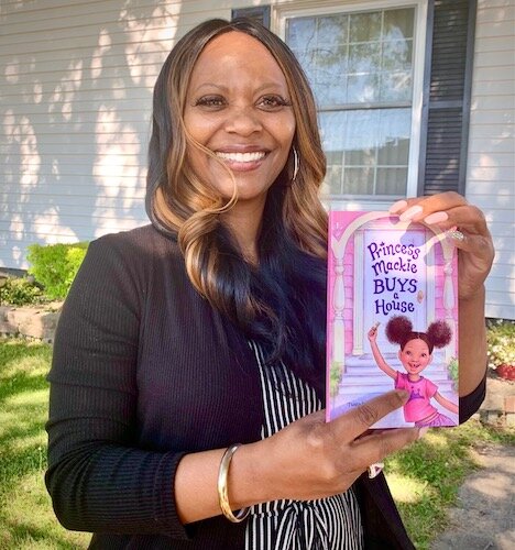 Twala Lockett-Jones holds a copy of her book, Princess Mackie Buys a House.