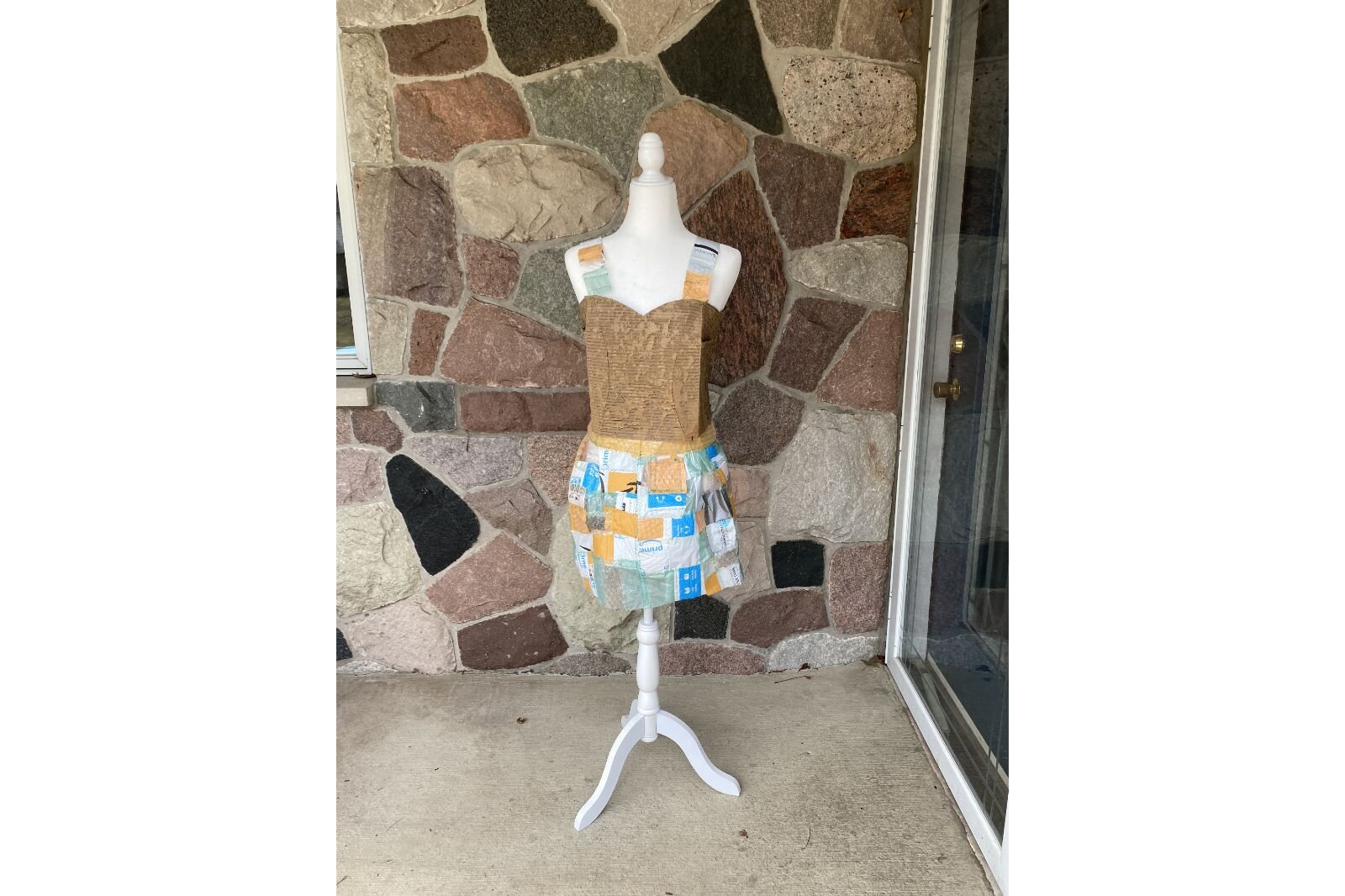  The finished “Plastic Patchwork Packing Dress” is appropriately showcased on a doorstep where a package might land.