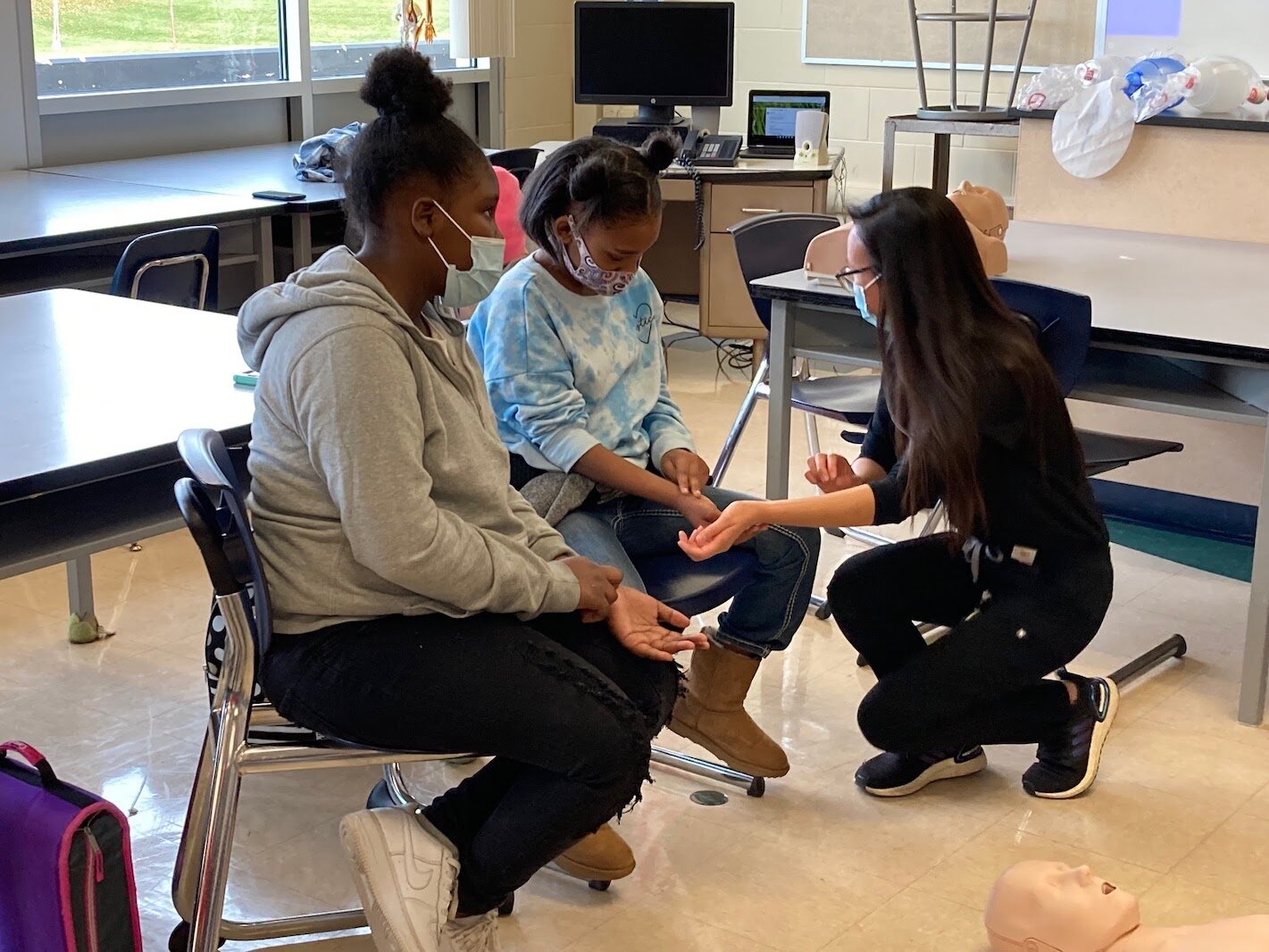 Christine Hua, a second-year medical student at the WMU Stryker School of Medicine, shows students how to check for a pulse during the Early Introduction to Health Careers 1.5 program at Milwood Magnet School. 
