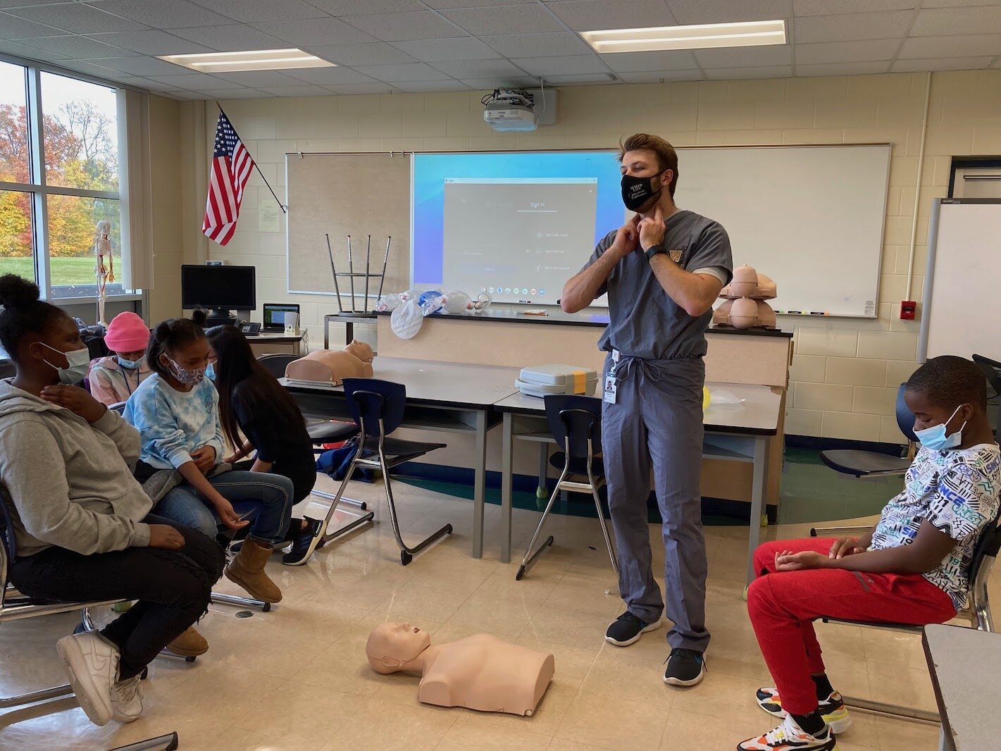  Kevin Steknik, a second-year medical student at the WMU Stryker School of Medicine, shows students how to check for a pulse during the Early Introduction to Health Careers 1.5 program at Milwood Magnet School. 