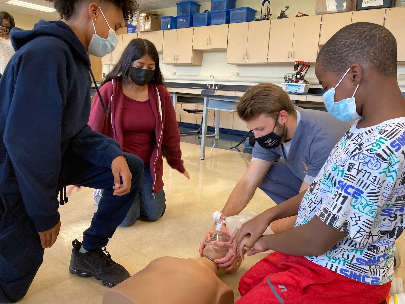 Kevin Steknik, a second-year medical student shows, from left, Jonavan Hare, Rose Hernandez, and Nathaniel Collier, how to bag a patient during the Early Introduction to Health Careers 1.5 program at Milwood Magnet School.