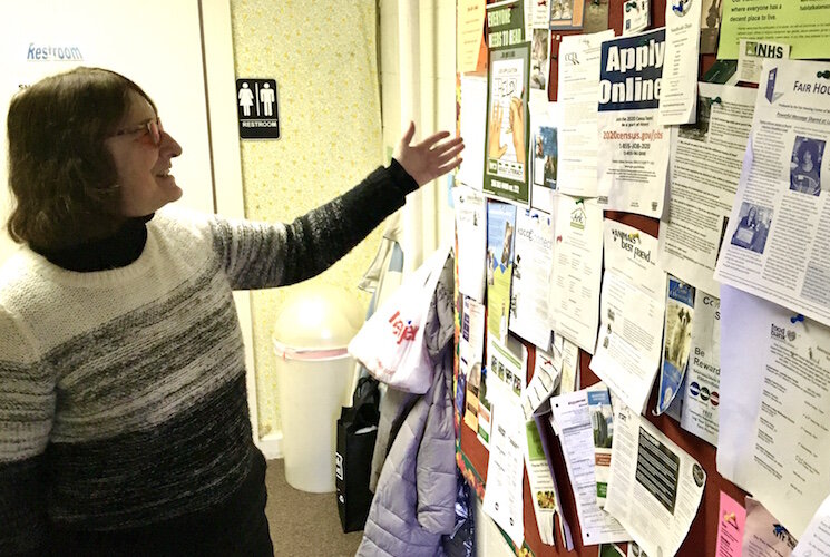 Cheryl Lord shows postings for programs and jobs on a bulletin board at the Oakwood Neighborhood Association offices.