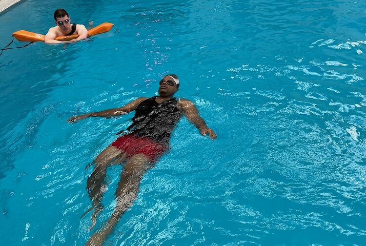 Henri Prudhomme, ALTS Assistant Instructor, watches Millard Southern practicing a back float.