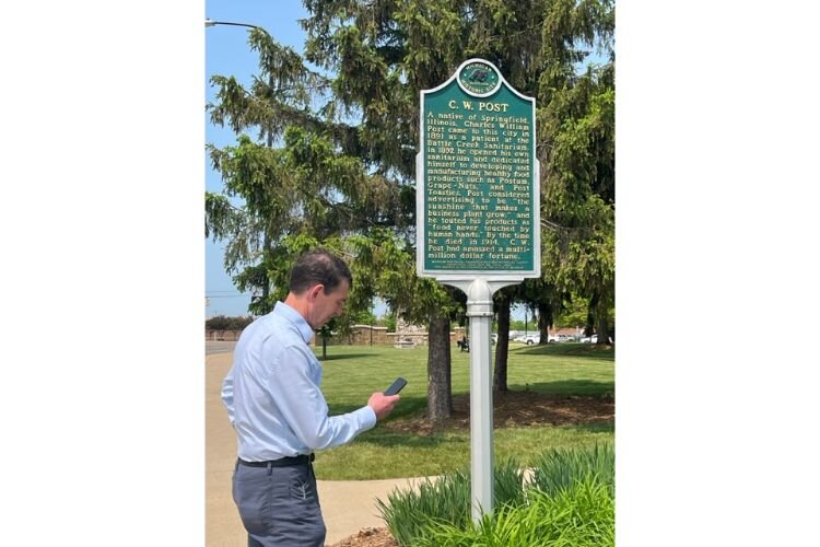 Mac McCullough at a historical marker in Battle Creek checking out the new Battle Creek history app.