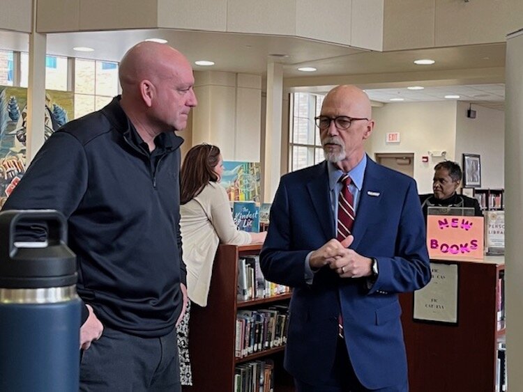 Dr. Steven M. Corey, President of Olivet University, at right, talks with an unidentified alumni of Battle Creek Central High School during the media event.