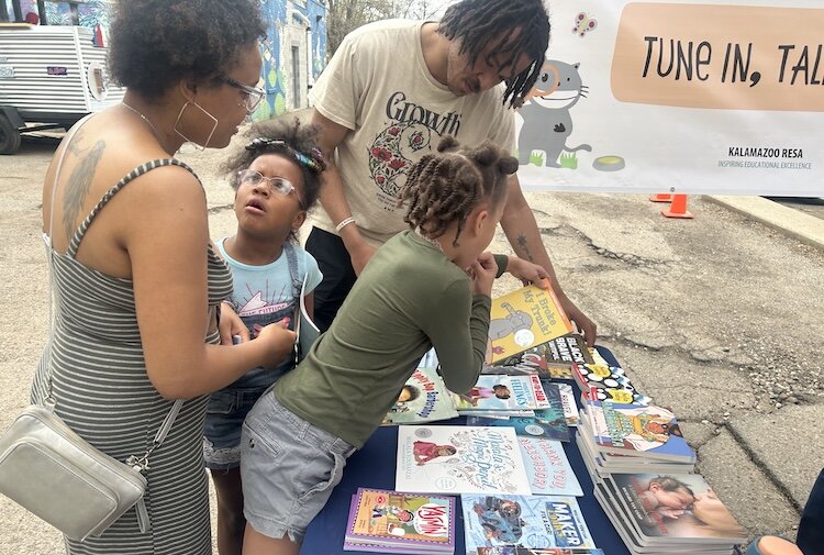 A Kalamazoo family lookis at the free books available at a Barbershop and Literacy event in the Vine Neighborhood. 