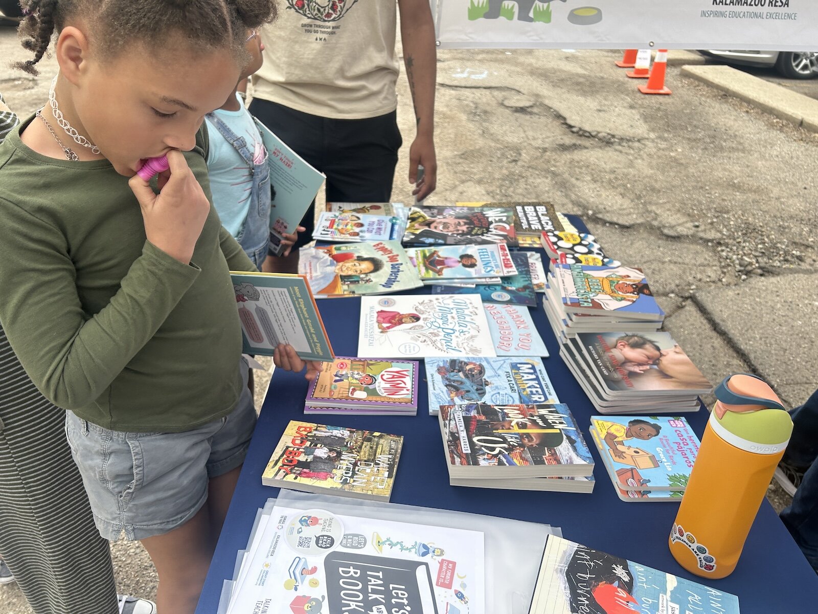 Decision, decisions. A young girl looks at the free boos available during a recent Barbershop and Literacy event in the Vine Neighborhood. 