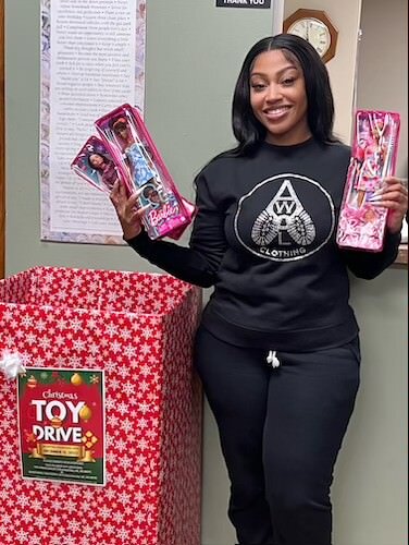 Shannon Patrick holds up toys that will be given to children attending her first annual Christmas Dinner on December 17 at First Congregational Church. The toys are being collected at the Southwestern Michigan Urban League.