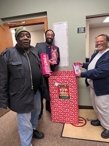 Carey Whitfield, President of the NAACP (National Association for the Advancement of Colored People) Battle Creek Branch, center, poses with fellow NAACP members holding donated toys.
