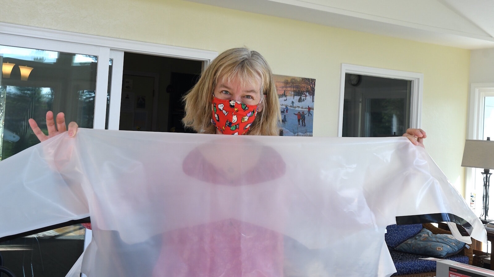 Barb Galonsky holds one of approximately 500 isolation gowns she and a group of local volunteers have made.