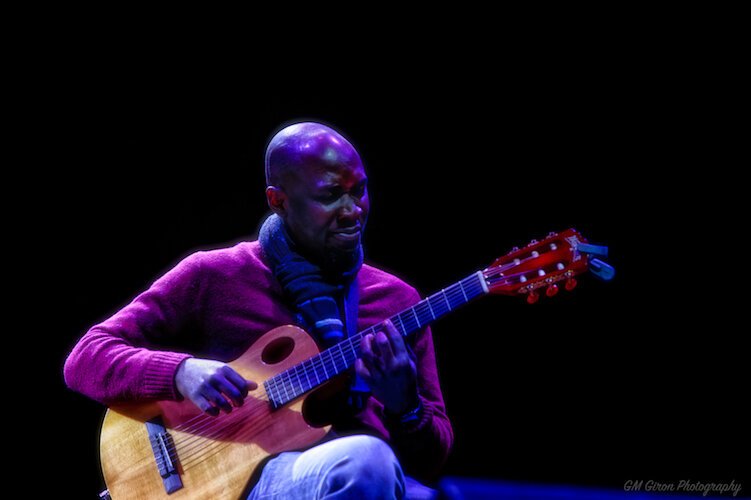 Ivan Akansiima plays guitar while Yolonda Lavender's sings her original song, "No Matter What”.