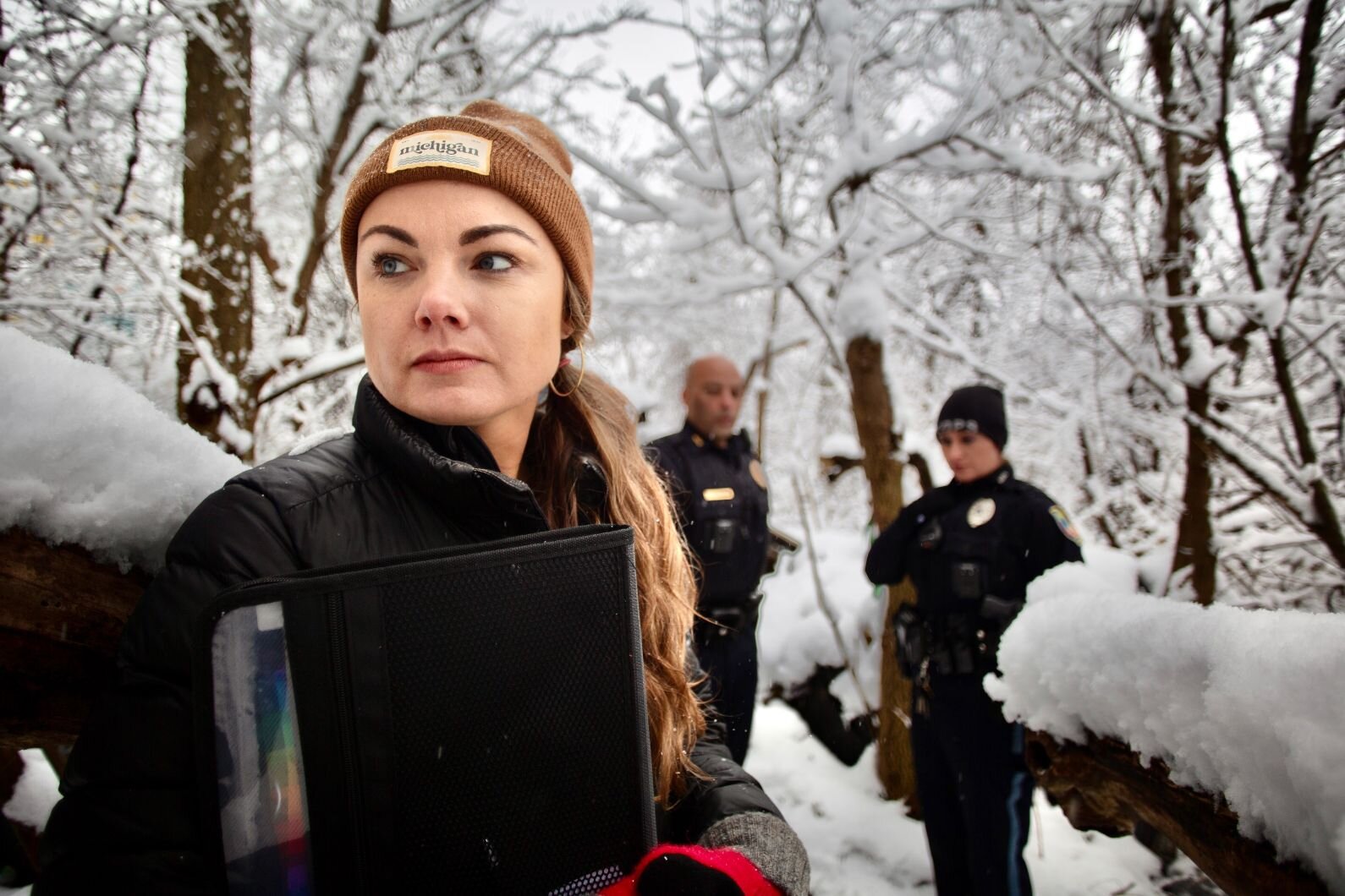 Kelsey Harness, social services coordinator for Kalamazoo Public Safety's new Community Service Team, looks around a wooded area where unhoused people  camped until recently east of downtown Kalamazoo.