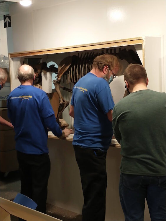 Staff and volunteers with the Kingman Museum prepare an item in the collection for the move out of the building.