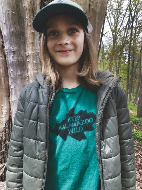 Hess Cameron wears a Keep Kalamazoo Wild T-shirt. It is some of the merchandise being sold to help the Stewards of Kleinstuck buy nearly 12 acres of wooded land adjacent to the Kleinstuck Preserve in Kalamazoo.