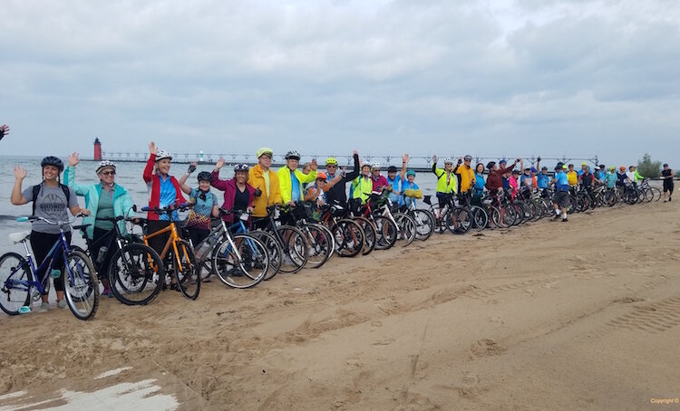 Riders dip their rear tire in Lake Michigan before taking off for Lake Huron