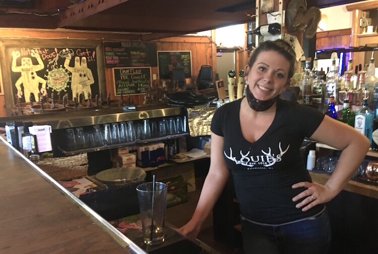 Assistant General Manager Anne Tremblay, with a protective face covering pulled down, awaits pickup/takeout customers at Louie’s Trophy House, 440 E. North St. on Kalamazoo’s near North Side.  