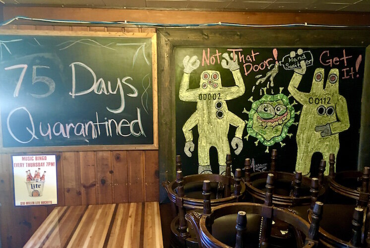 Some young customers used a large chalkboard at Louie’s Trophy House to draw monsters attacking a coronavirus molecule. Another board shows how long the place has been without sit-down service. (The count was through June  30).